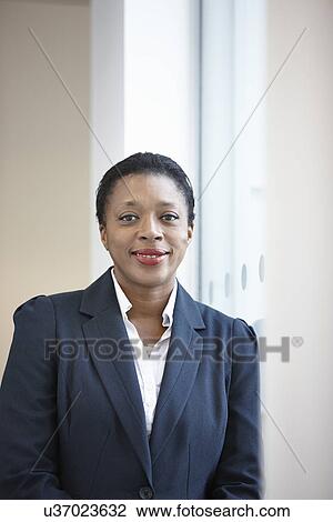 Stock Image - Portrait of businesswoman looking at camera. Fotosearch