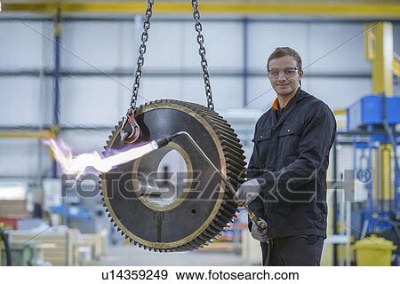 Portrait of engineer heat treating industrial gear in factory View Large Photo Image Stock Photo - Portrait of engineer heat treating industrial gear in factory. Fotosearch