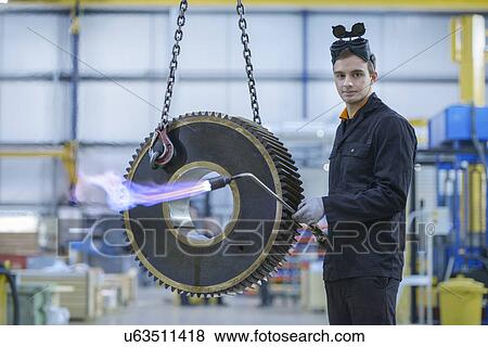 Portrait of engineer heat treating industrial gear in factory View Large Photo Image Stock Photo - Portrait of engineer heat treating industrial gear in factory. Fotosearch