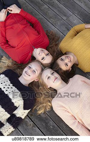 Stock Photo - Portrait of four teenage girls head to head on patio. Fotosearch