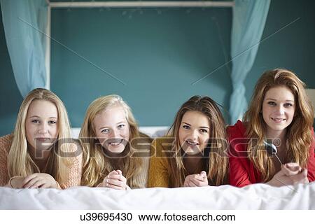 Portrait of four teenage girls lying on bed View Large Photo Image Stock Image - Portrait of four teenage girls lying on bed. Fotosearch