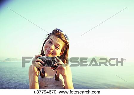 Stock Image - Portrait of girl holding camera on holiday, Kas, Turkey. Fotosearch