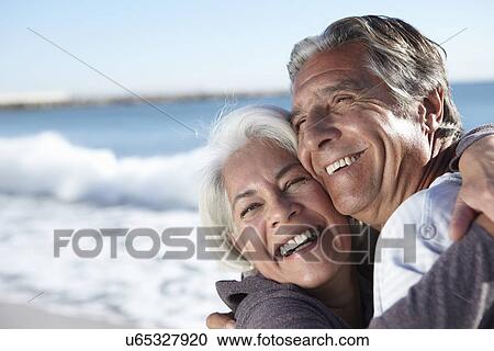 Portrait of happy couple by seaside View Large Photo Image Stock Image - Portrait of happy couple by seaside. Fotosearch