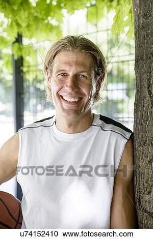 Stock Image - Portrait of male basketball player in park. Fotosearch