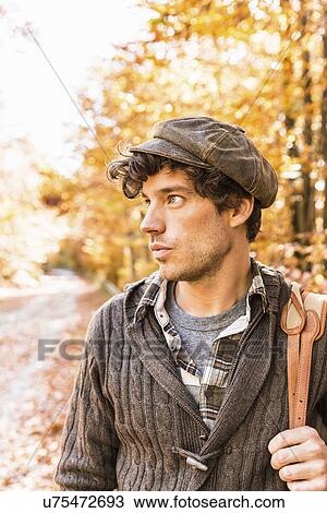 Stock Image - Portrait of man wearing brown cap and cardigan. Fotosearch