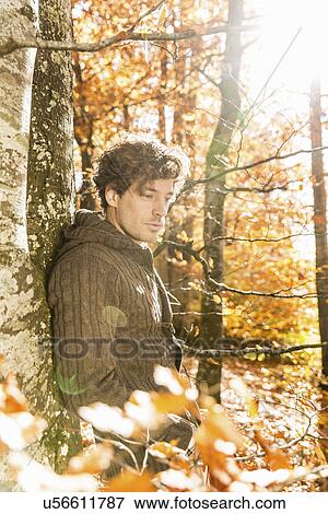 Stock Photo - Portrait of man wearing cardigan in forest. Fotosearch