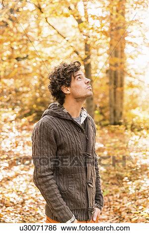 Portrait of man wearing cardigan in forest looking up View Large Photo Image Stock Photograph - Portrait of man wearing cardigan in forest looking up. Fotosearch