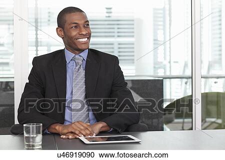 Stock Image - Portrait of mid adult businessman in office. Fotosearch