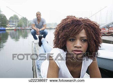 Portrait of sad looking young woman with man in background View Large Photo Image Stock Photo - Portrait of sad looking young woman with man in background. Fotosearch