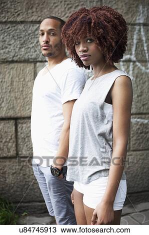 Stock Image - Portrait of serious young couple looking at camera. Fotosearch