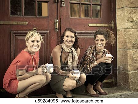 Portrait of three young woman with coffee cups taking a break outside View Large Photo Image Stock Photography - Portrait of three young woman with coffee cups taking a break outside. Fotosearch