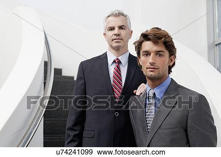 Stock Photo - Portrait of two businessmen on office stairs. Fotosearch