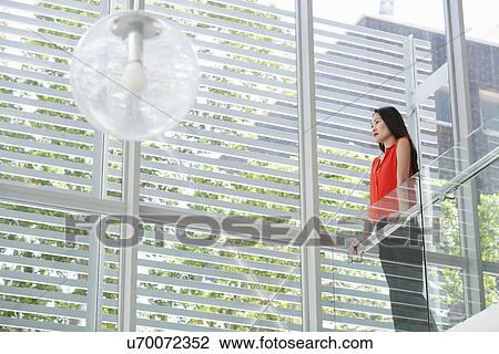 Stock Image - Portrait of young businesswoman in office atrium. Fotosearch