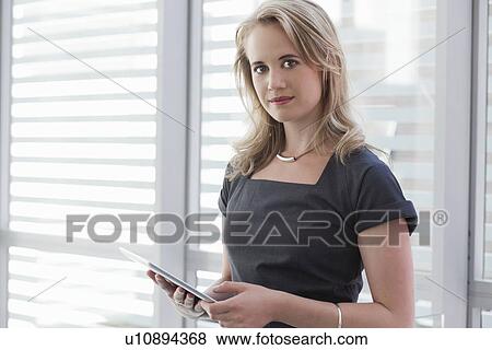 Stock Photo - Portrait of young businesswoman using digital tablet. Fotosearch