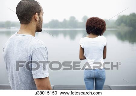 Portrait of young couple by lake, rear view View Large Photo Image Stock Image - Portrait of young couple by lake, rear view. Fotosearch