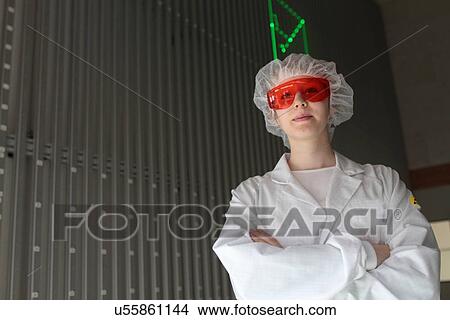 Picture - Portrait of young female scientist in laser laboratory. Fotosearch