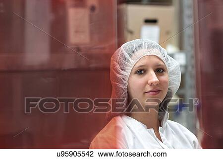 Stock Image - Portrait of young female scientist in laser laboratory storeroom. Fotosearch