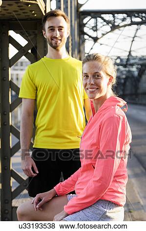 Portrait of young male and female runners on bridge View Large Photo Image Stock Photo - Portrait of young male and female runners on bridge. Fotosearch