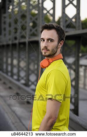 Stock Image - Portrait of young male runner on bridge. Fotosearch