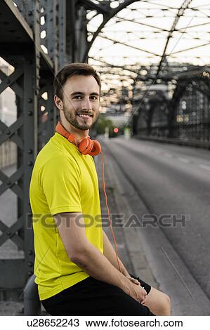 Portrait of young male runner taking a break on bridge View Large Photo Image Stock Image - Portrait of young male runner taking a break on bridge. Fotosearch