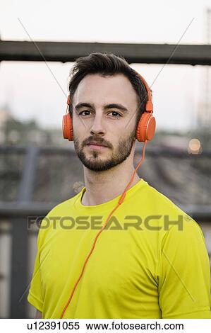 Stock Photography - Portrait of young male runner wearing headphones. Fotosearch