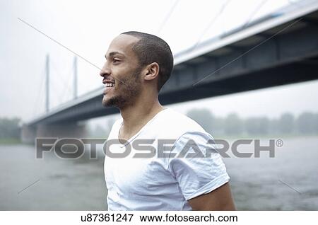 Portrait of young man by bridge, Dusseldorf, Germany View Large Photo Image Stock Photo - Portrait of young man by bridge, Dusseldorf, Germany. Fotosearch