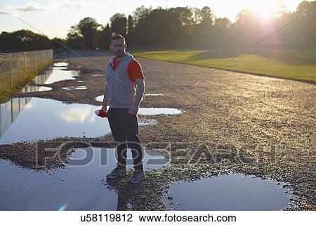 Portrait of young man standing in puddle View Large Photo Image Stock Image - Portrait of young man standing in puddle. Fotosearch