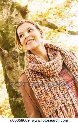 Portrait of young woman wearing knitted scarf View Large Photo Image Stock Photo - Portrait of young woman wearing knitted scarf. Fotosearch
