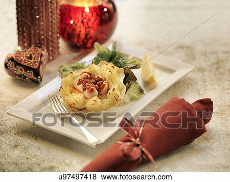Queen scallops gratin with calabrian sausage on a mashed potato filled scallop shell amongst festive decorations View Large Photo Image Stock Photo - Queen scallops gratin with calabrian sausage on a mashed potato filled scallop shell amongst festive decorations. Fotosearch