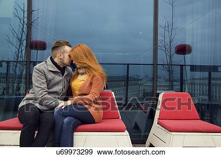 Romantic young couple sitting outdoors on rooftop terrace View Large Photo Image Stock Photo - Romantic young couple sitting outdoors on rooftop terrace. Fotosearch