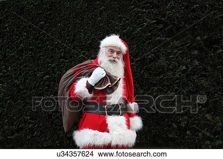 Picture - Santa Claus carrying sack over shoulder. Fotosearch