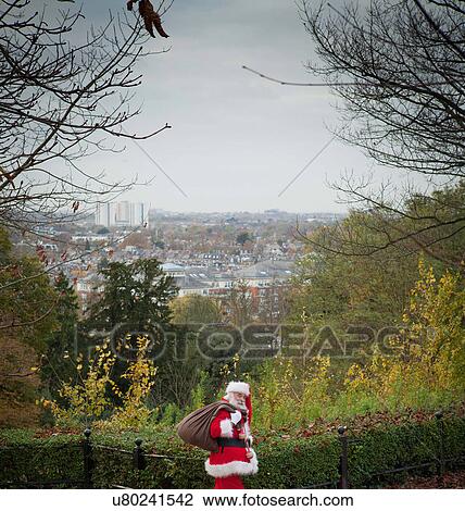Santa Claus carrying sack over shoulder View Large Photo Image Stock Image - Santa Claus carrying sack over shoulder. Fotosearch