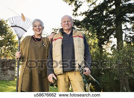 Senior couple holding rake and pruner View Large Photo Image Stock Image - Senior couple holding rake and pruner. Fotosearch