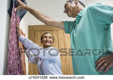 Senior couple making decision on wallpaper View Large Photo Image Stock Photo - Senior couple making decision on wallpaper. Fotosearch