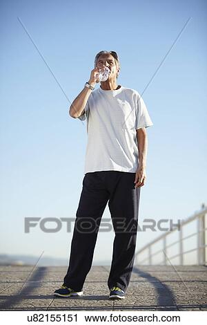Senior man drinking water on walk View Large Photo Image Stock Image - Senior man drinking water on walk. Fotosearch