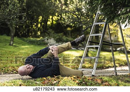 Senior man grimacing over injured knee View Large Photo Image Stock Image - Senior man grimacing over injured knee. Fotosearch