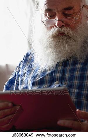 Stock Photo - Senior man using digital tablet. Fotosearch