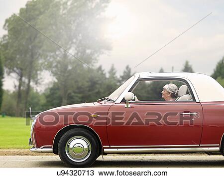 Senior woman driving along in red convertible View Large Photo Image Stock Image - Senior woman driving along in red convertible. Fotosearch
