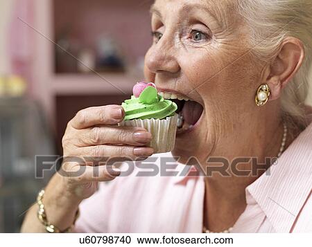 Senior woman enjoying cupcake in cafe View Large Photo Image Stock Image - Senior woman enjoying cupcake in cafe. Fotosearch