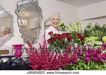 Stock Image - Senior woman in florist shop. Fotosearch