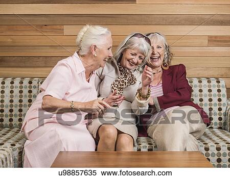 Senior women friends laughing on sofa View Large Photo Image Stock Photography - Senior women friends laughing on sofa. Fotosearch