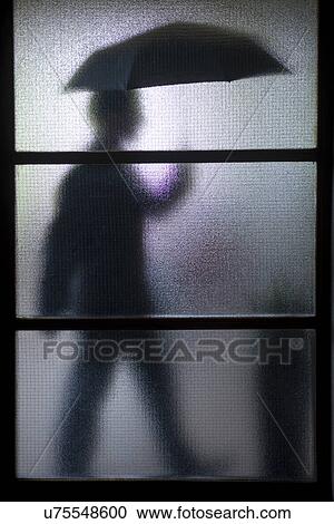 Silhouette of businessman carrying umbrella behind frosted glass View Large Photo Image Stock Image - Silhouette of businessman carrying umbrella behind frosted glass. Fotosearch