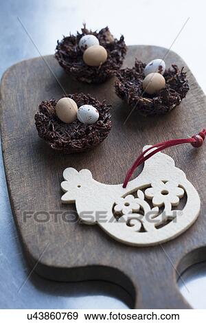 Stock Photo - Still life of chocolate easter eggs in chocolate nests on cutting board. Fotosearch