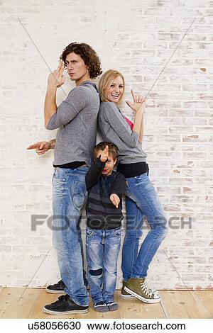 Studio portrait of couple and son making gun hand gestures View Large Photo Image Stock Image - Studio portrait of couple and son making gun hand gestures. Fotosearch