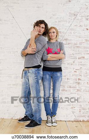 Picture - Studio portrait of couple making gun hand gestures. Fotosearch