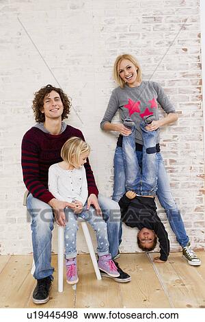 Stock Photo - Studio portrait of couple waving fun with son and daughter. Fotosearch