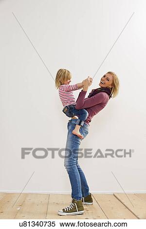 Stock Photography - Studio portrait of mother playing with young daughter. Fotosearch