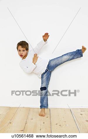 Stock Photo - Studio shot of boy doing karate kick. Fotosearch