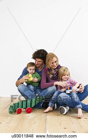 Stock Photo - Studio shot of couple with two young daughters. Fotosearch