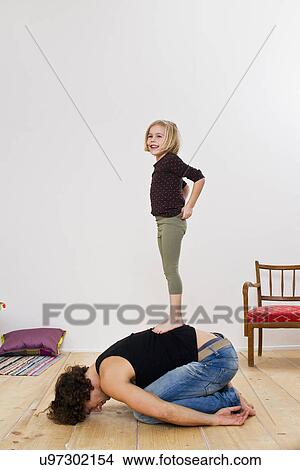 Picture - Studio shot of daughter standing on top of father. Fotosearch
